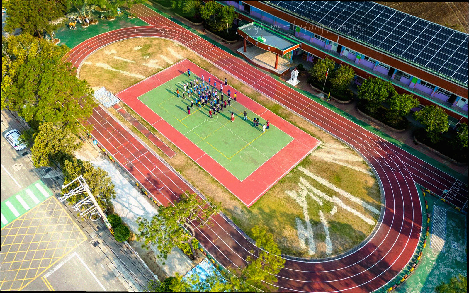 城市夜景中亮灯的足球场航拍，看台灯带呈斜向排列，画面偏冷蓝底调